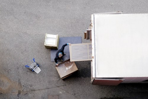 Professional team handling piano removals in Bow with protective equipment