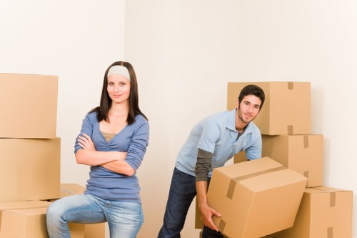 Professional movers loading furniture into a van in Bow
