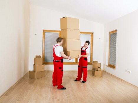 Moving team unloading boxes and furniture at a new home in Bow